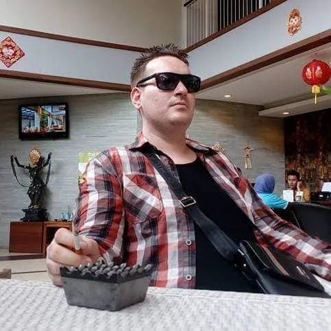 Shafaet seated indoors wearing sunglasses